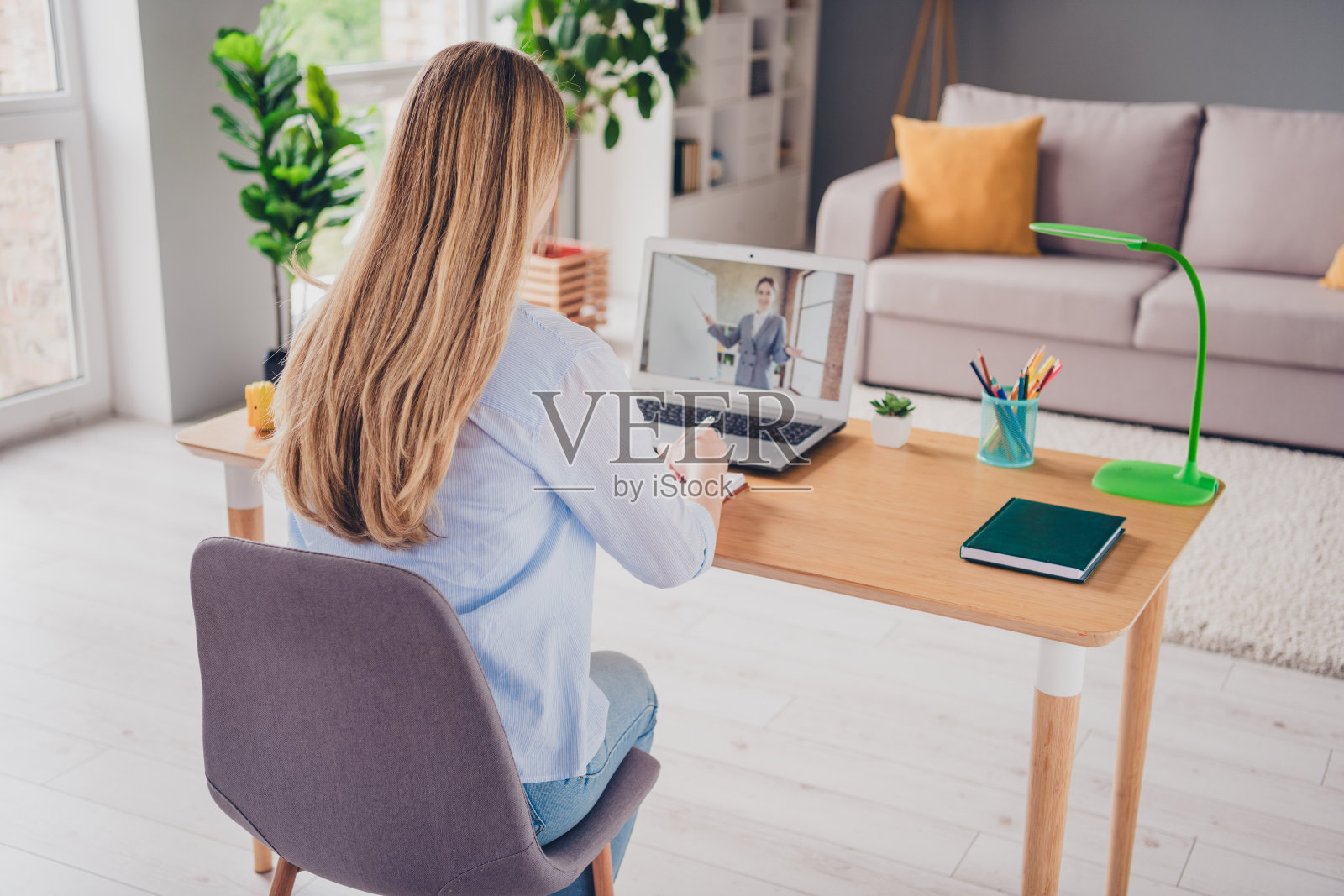 漂亮女士穿着休闲衬衫的照片，距离放大在室内学习现代设备照片摄影图片
