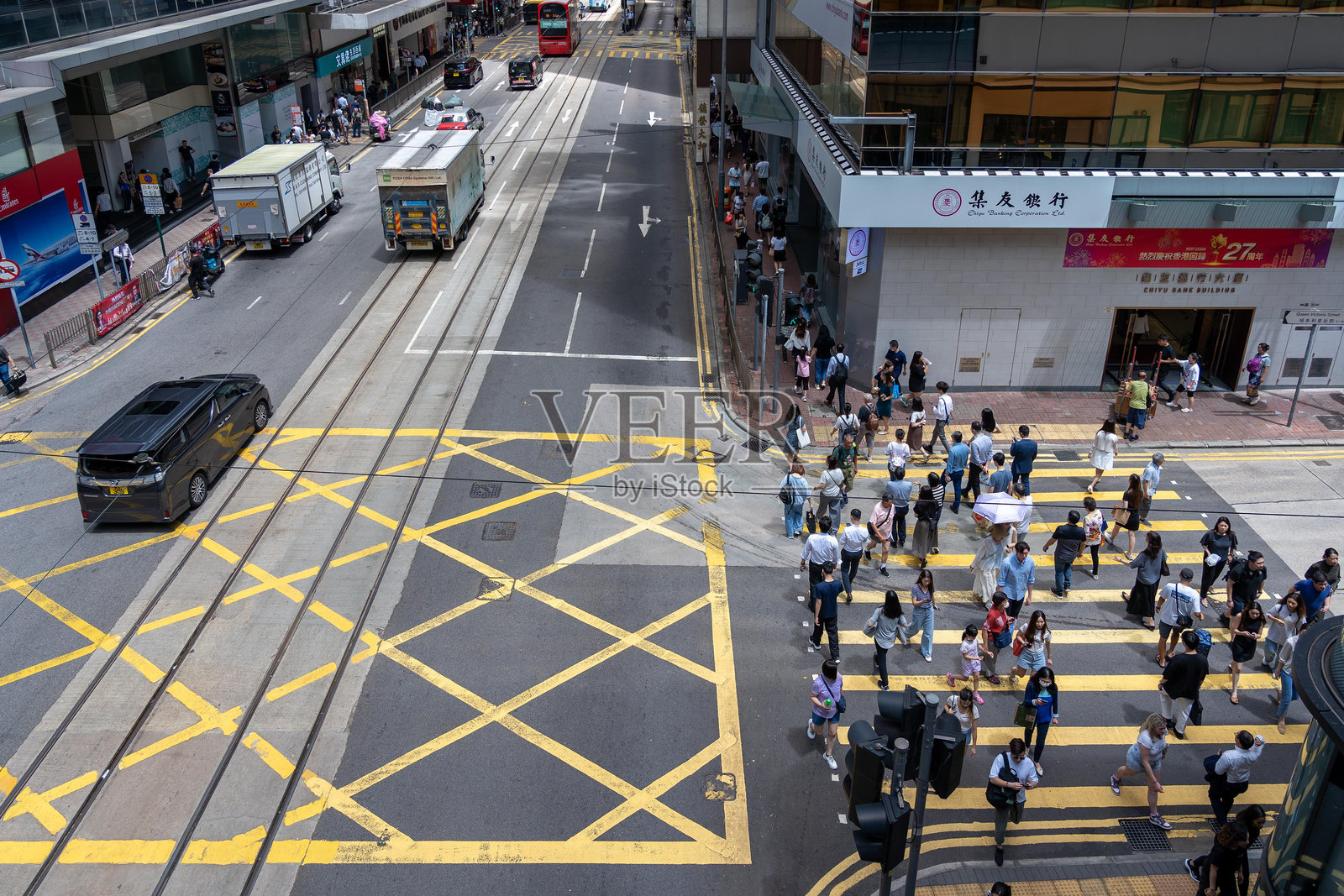 中国香港一个繁忙的十字路口,行人过马路,车辆驶过。照片摄影图片
