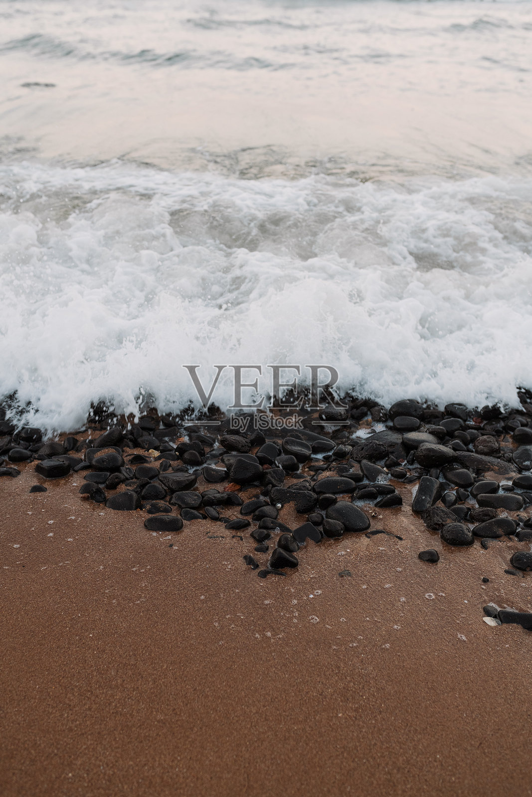 海浪拍打着海滩上的黑色岩石照片摄影图片