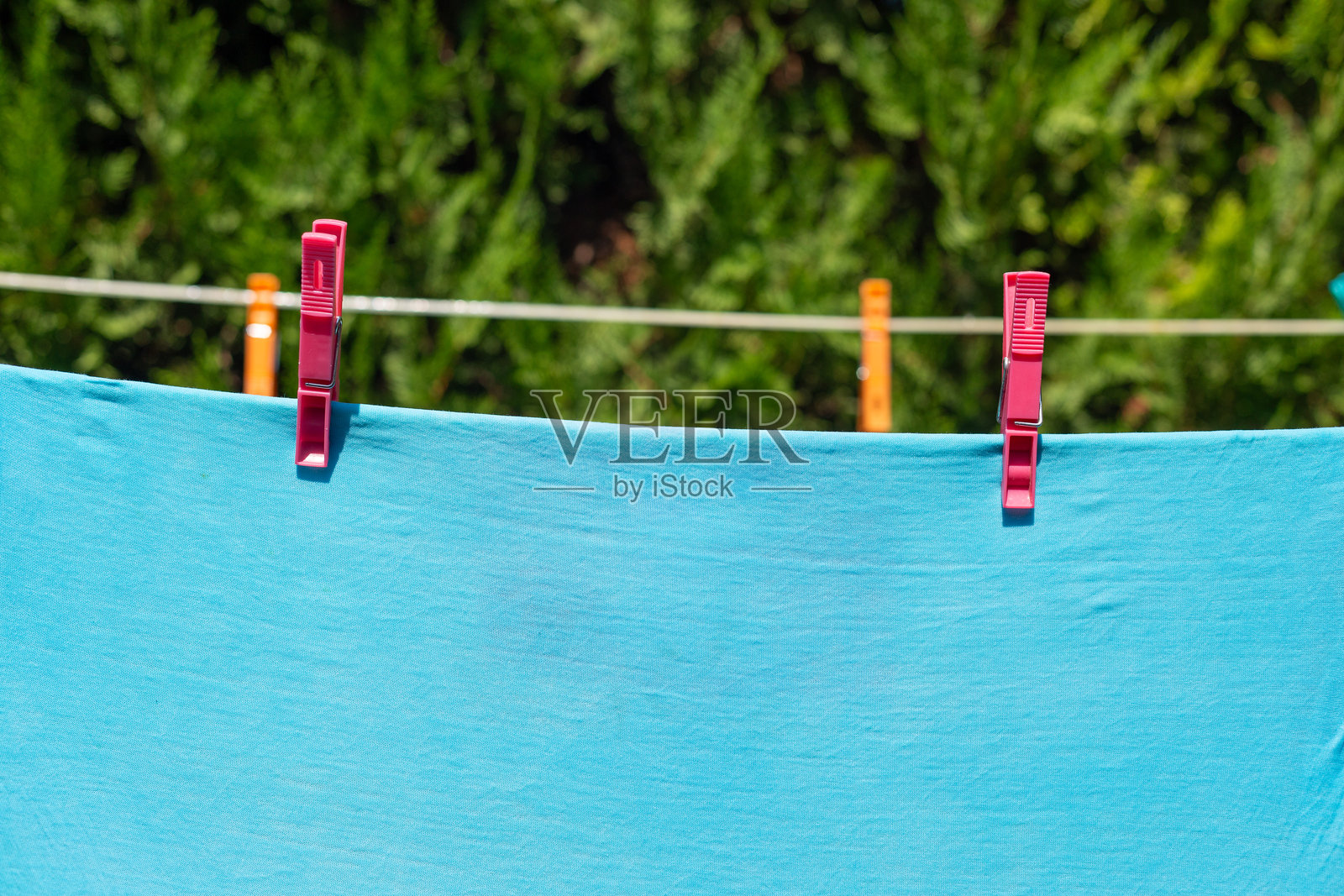 浅蓝色t恤洗完后晾在太阳下照片摄影图片