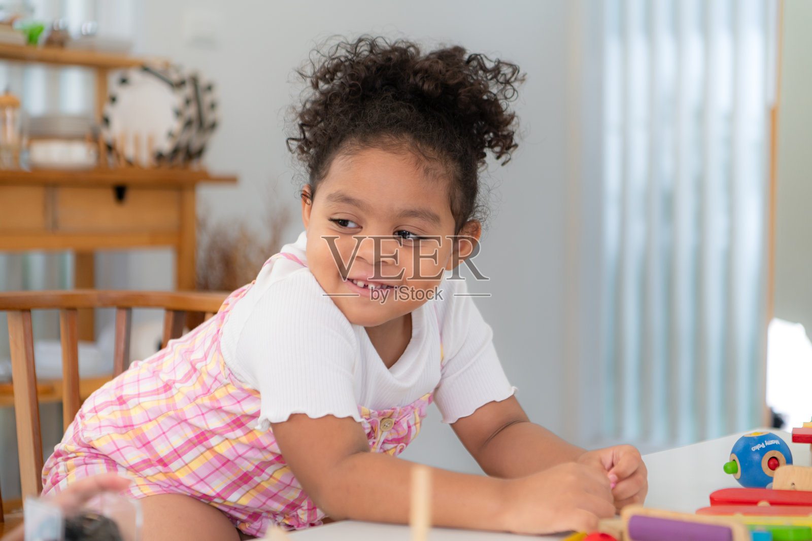 一个小女孩坐在地板上，坐在地板上玩玩具照片摄影图片