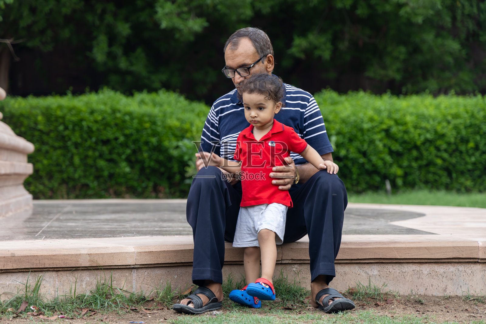 晚上爷爷在公园里教孙子关于自然的知识照片摄影图片
