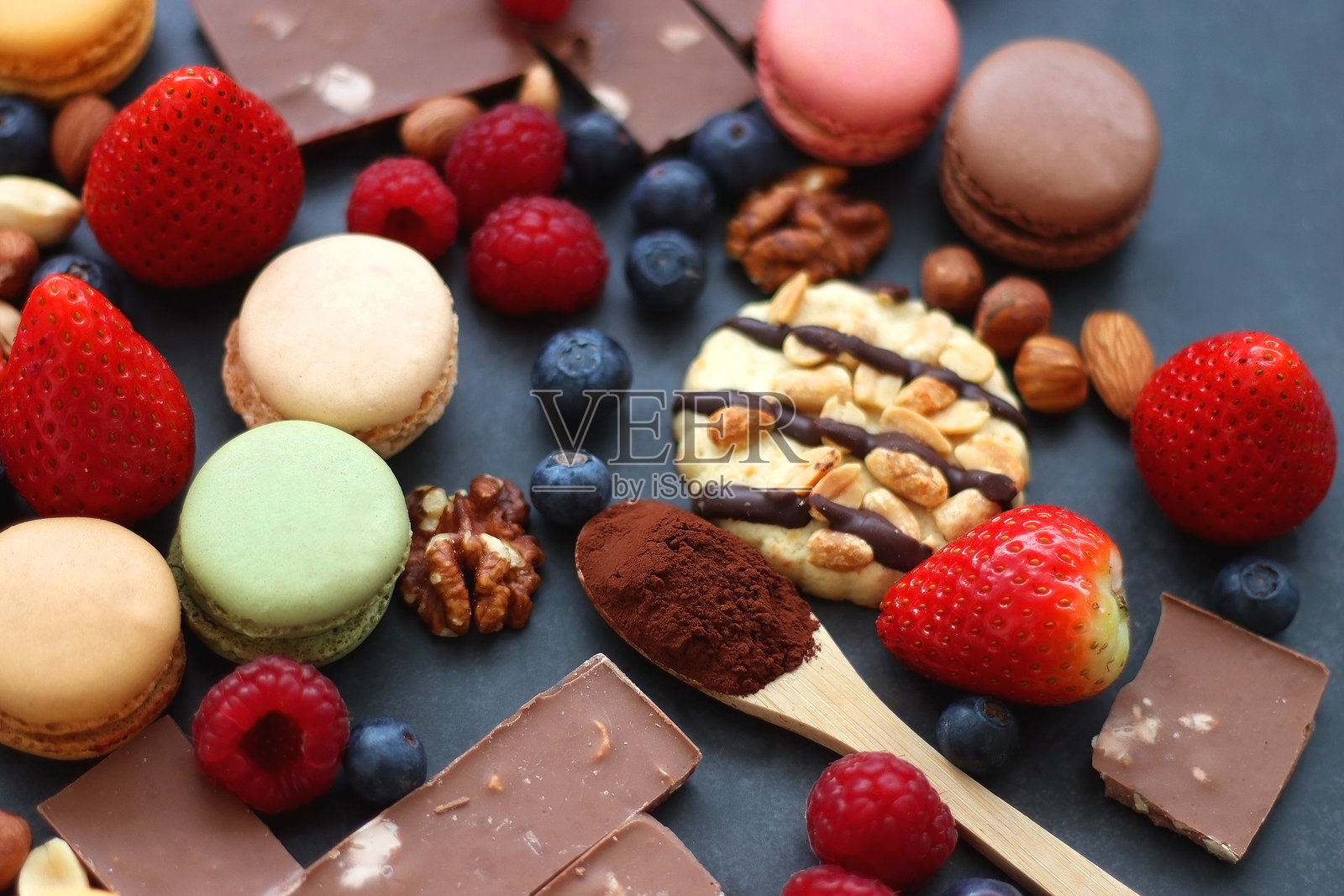 糖果，浆果和坚果在黑暗的背景照片摄影图片