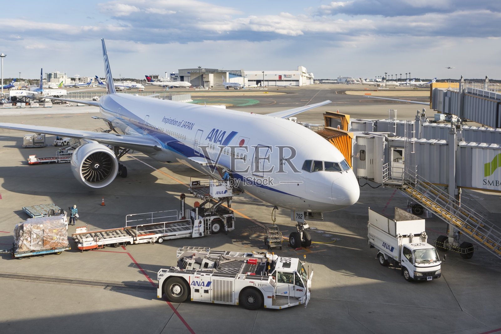 工人们把行李搬上全日空航空公司的飞机。照片摄影图片