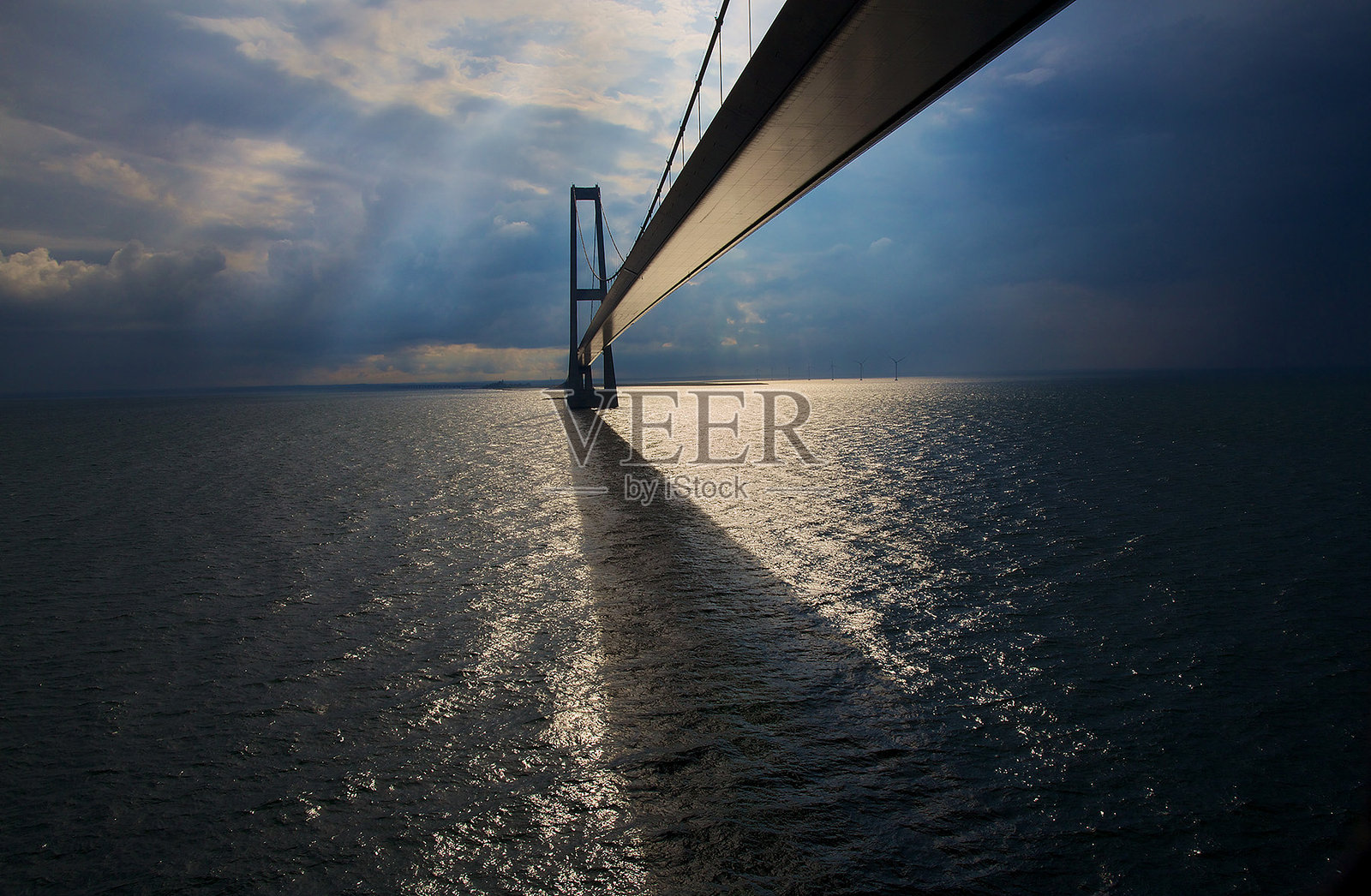 在多云的天空下俯瞰大海的桥照片摄影图片