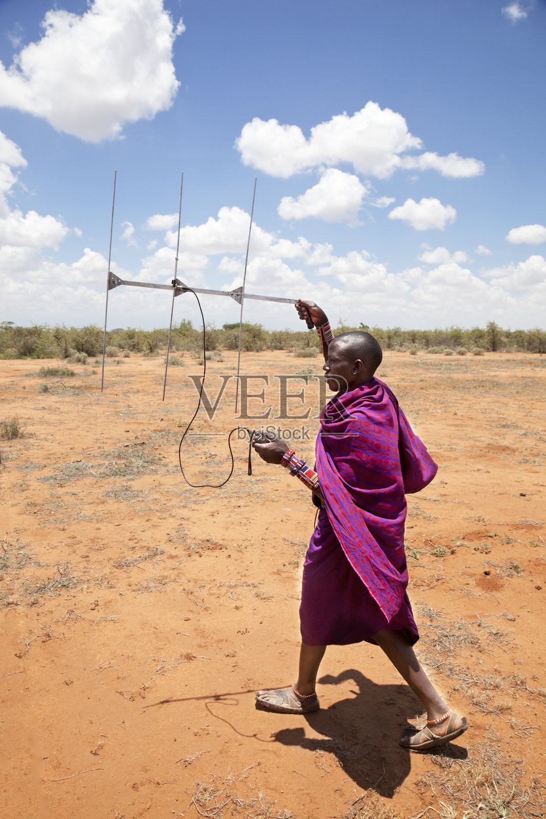 年轻的马赛人有无线电定位设备。照片摄影图片