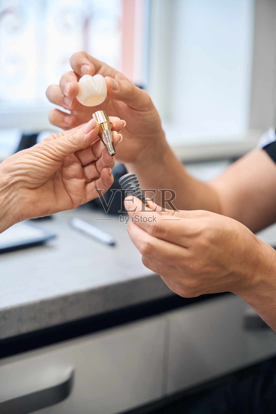 义齿医生向病人展示植牙模型照片摄影图片