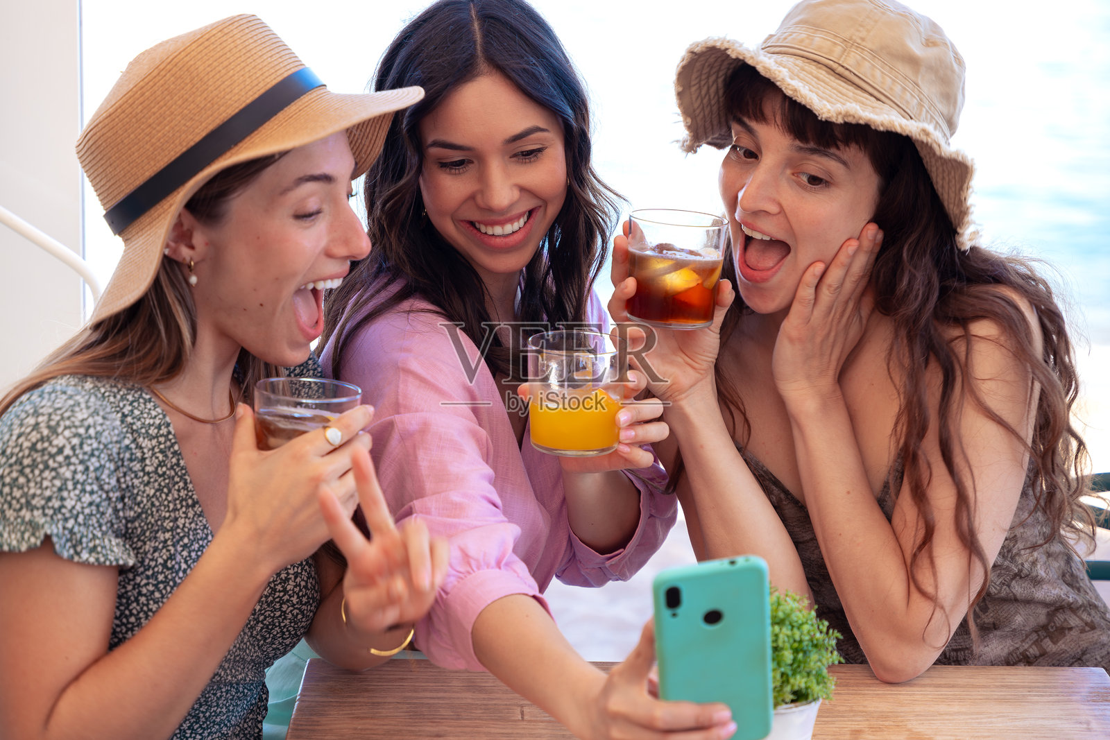 三个穿着夏装的年轻朋友在餐厅自拍照片摄影图片