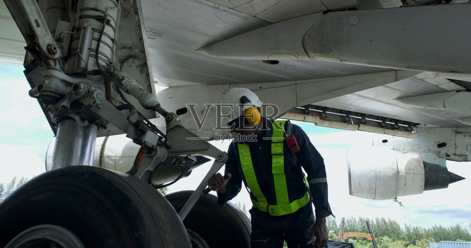 黑人男性飞机机械师使用手工工具检查和维护飞机，飞机技师在机库检查飞机照片摄影图片