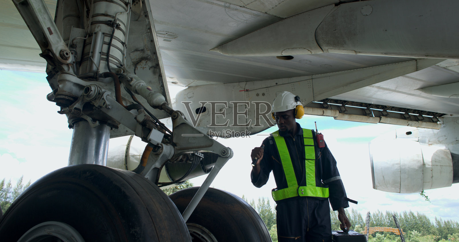 黑人男性飞机机械师使用手工工具检查和维护飞机，飞机技师在机库检查飞机照片摄影图片