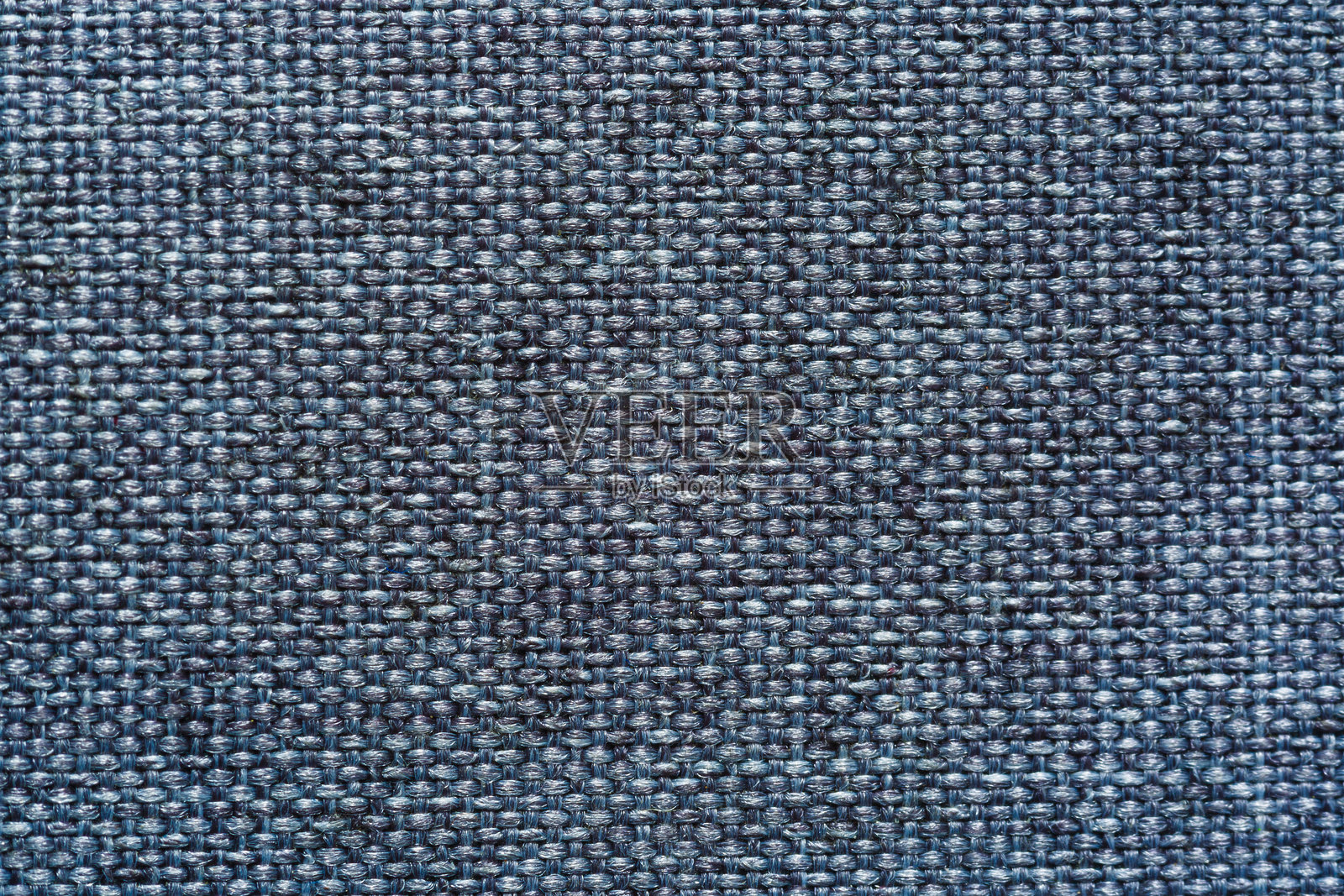 宏观织物纹理为灰色，近景织物纹理为自然浅灰色的粗织织物或布。天然棉或麻纺织材料的织物质地。蓝色画布背景。室内装潢、家具用装饰织物照片摄影图片