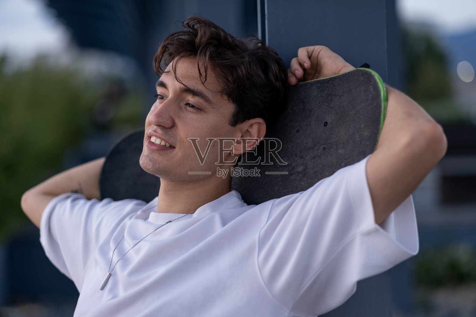 一个肩上扛着滑板的年轻人的肖像照片摄影图片