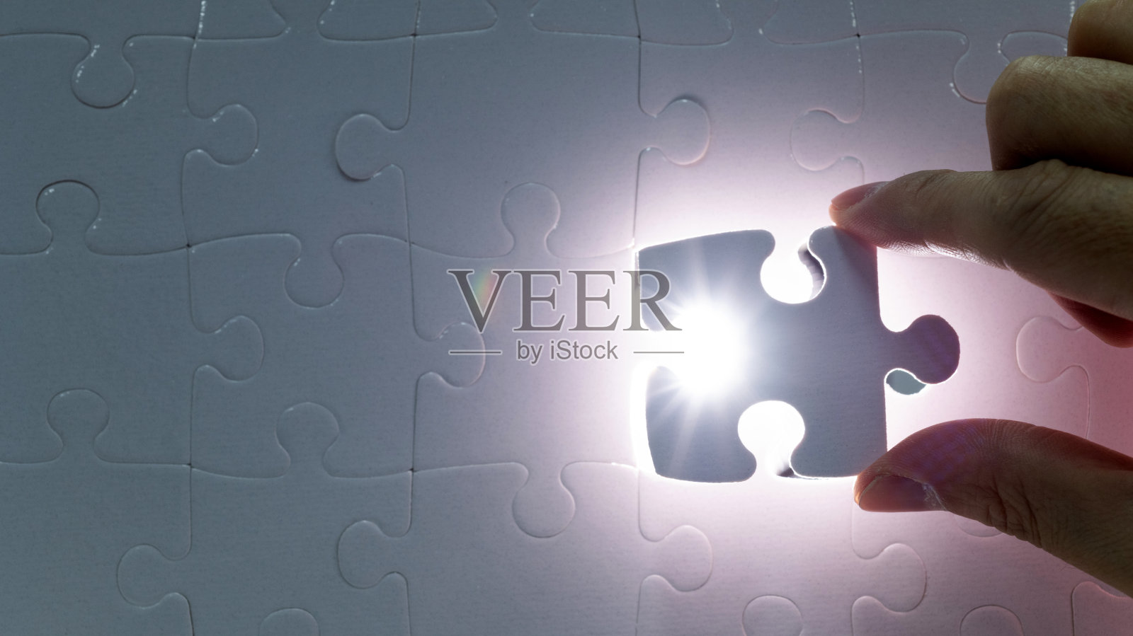 人类的手握着最后一块拼图照片摄影图片