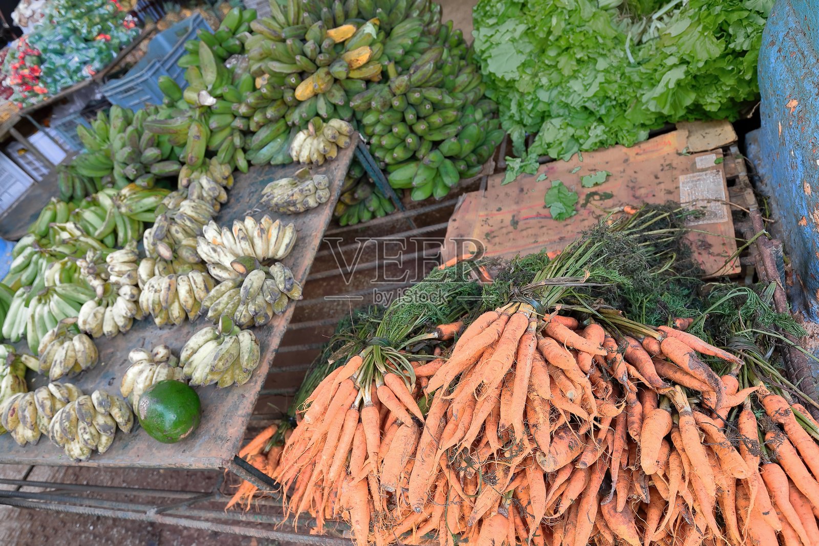 香蕉手、胡萝卜串、生菜和一个芒果，在埃尔维达多第五消防站旁边的大街23大道的一个街头市场摊位上。哈瓦那,古巴,660照片摄影图片