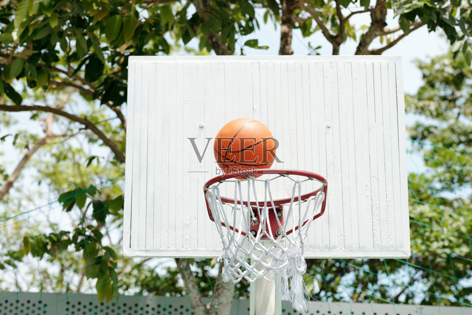 户外的篮球圈，球穿过球网照片摄影图片