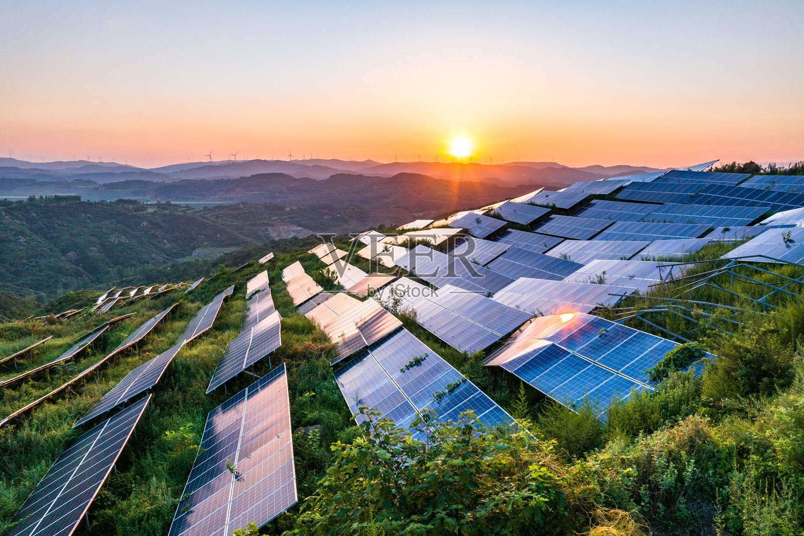 航拍山坡上光伏太阳能发电站照片摄影图片