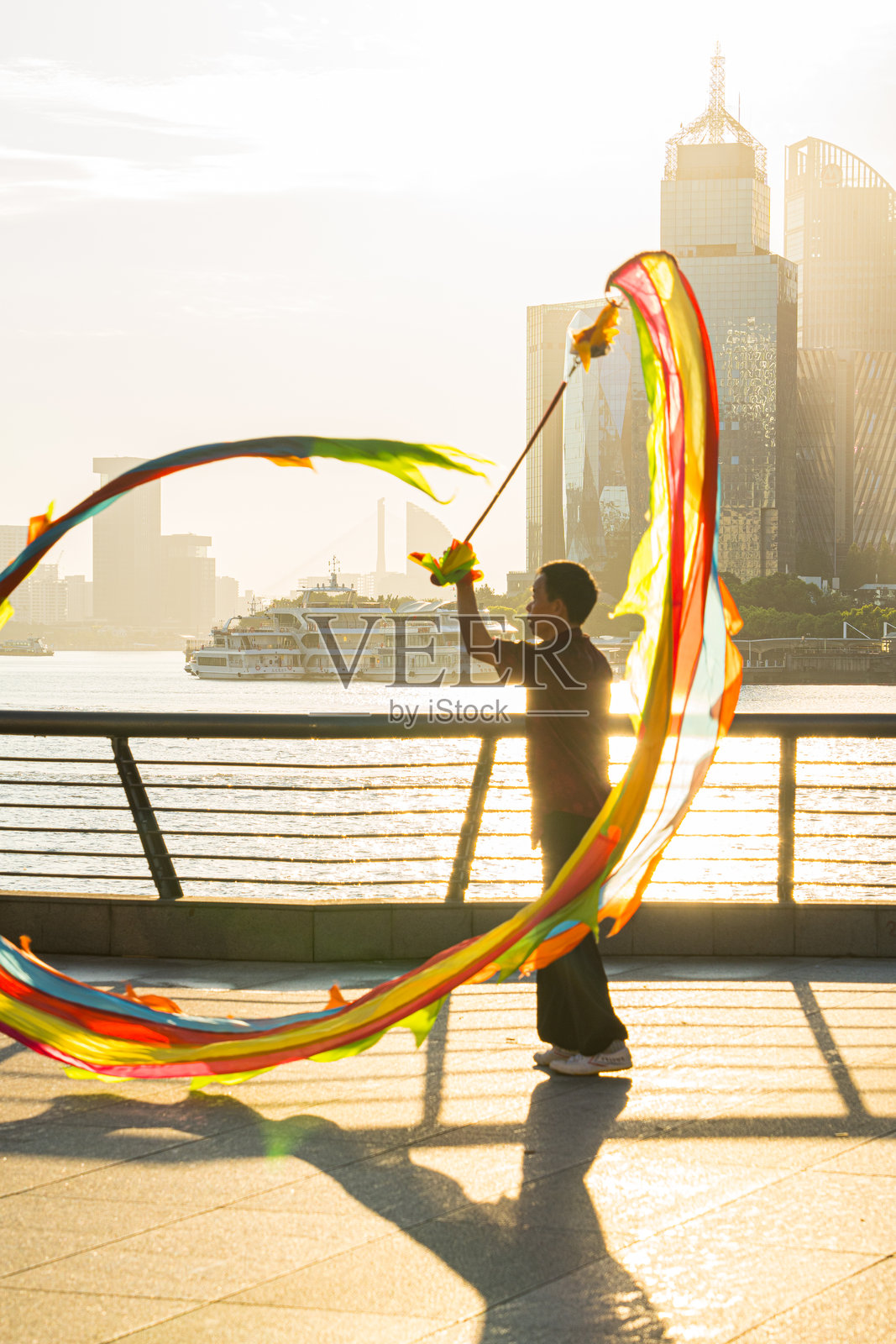 上午，在中国上海外滩，人们正在练习彩带舞龙。照片摄影图片
