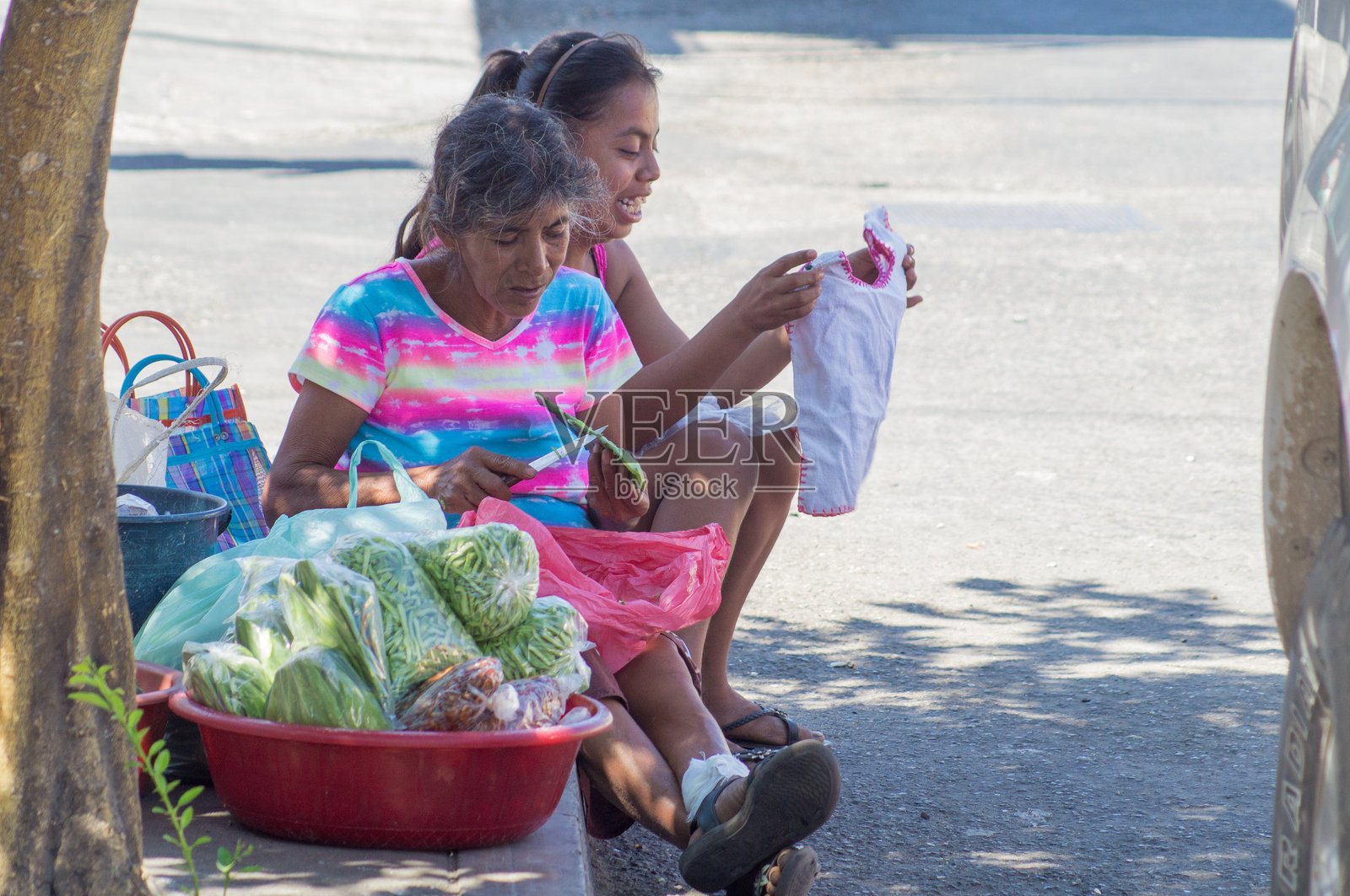 街头女商人在街上卖土豆照片摄影图片