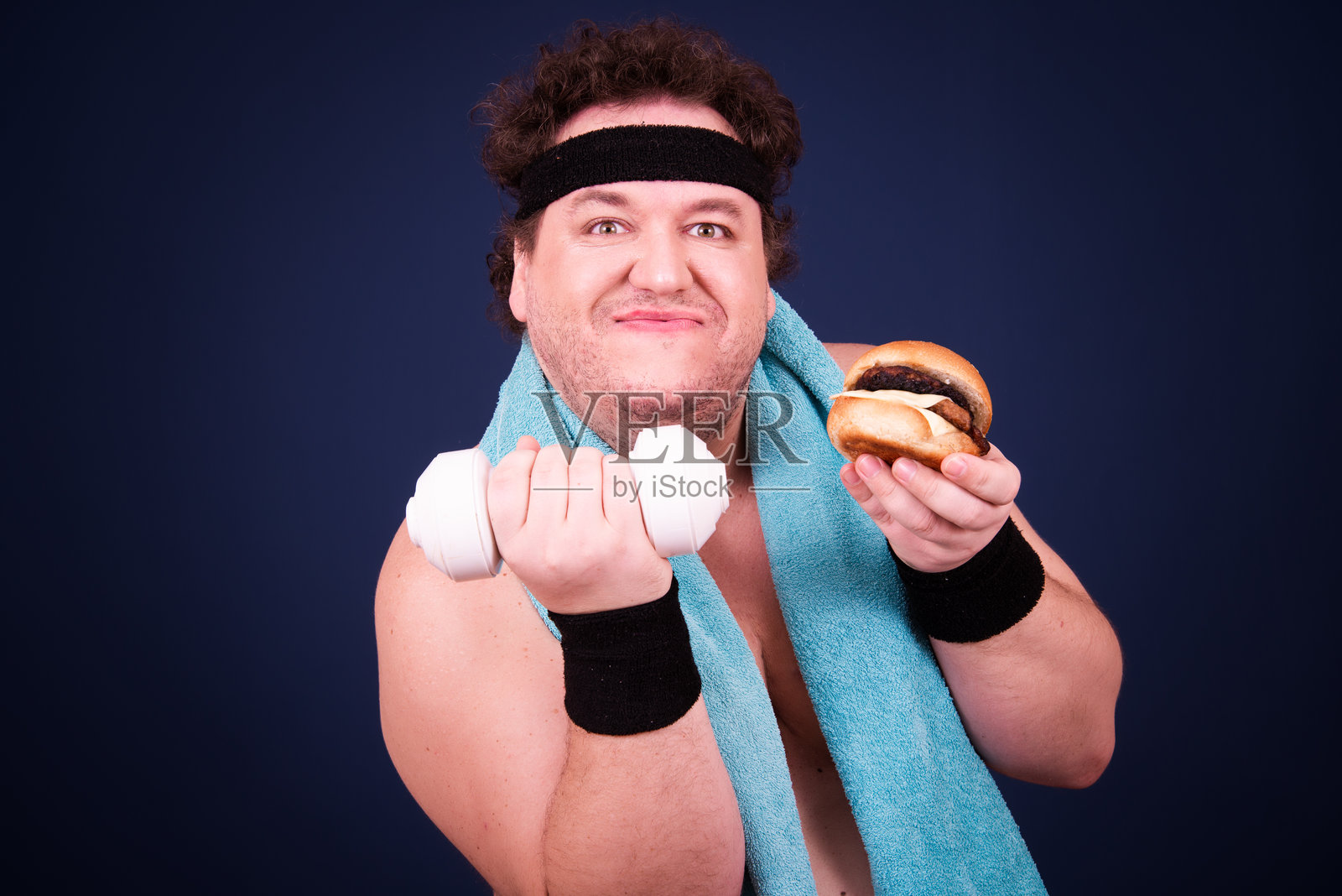 滑稽的胖子和他的不良饮食习惯。蓝色背景。照片摄影图片