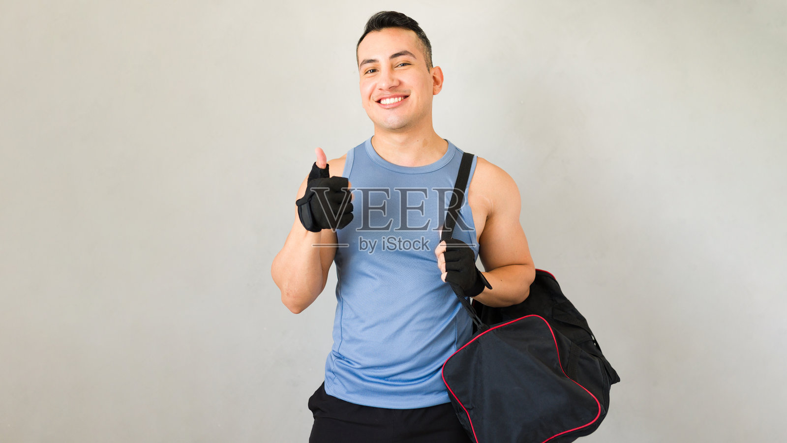 训练成功后，运动员拿着运动包，竖起大拇指照片摄影图片