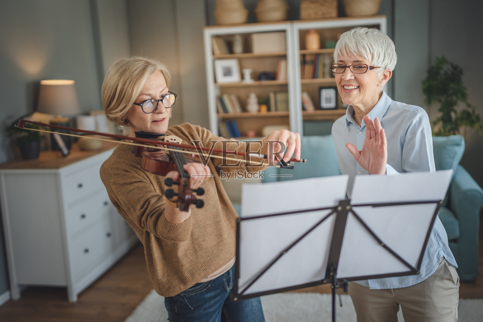 私人音乐老师在家里给成熟的老年妇女上小提琴课照片摄影图片