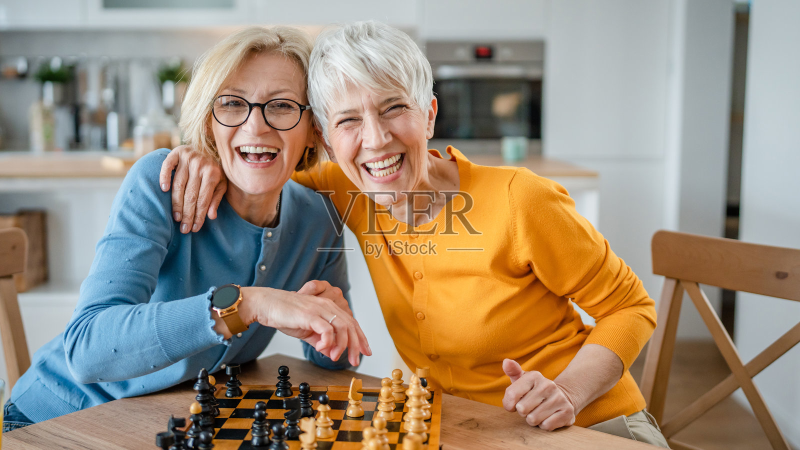 两个女人成熟的高级女姐妹在家里下棋棋盘游戏照片摄影图片