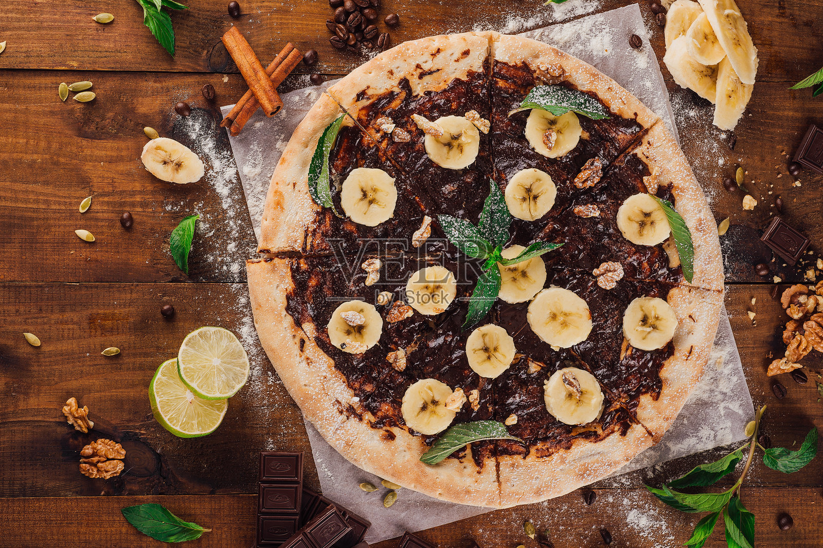 美味的甜披萨，巧克力，香蕉和薄荷在木制桌子上照片摄影图片