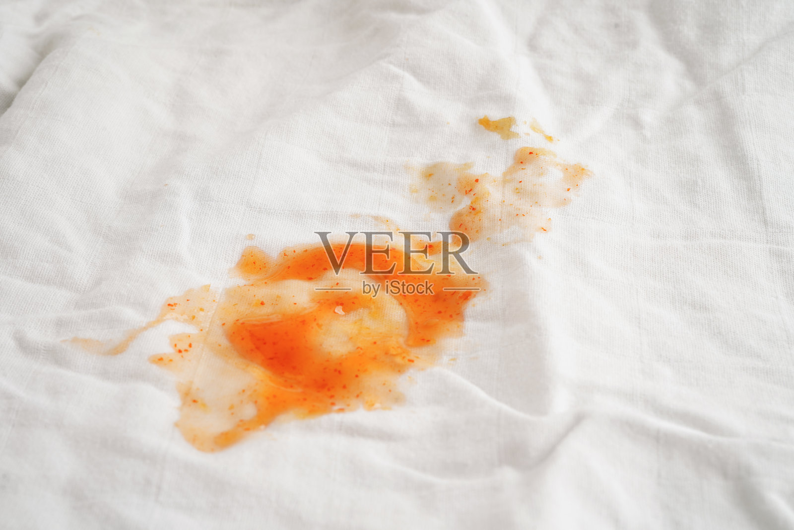 脏的辣酱渍在布上要用洗衣粉洗，清洁家务的概念。照片摄影图片