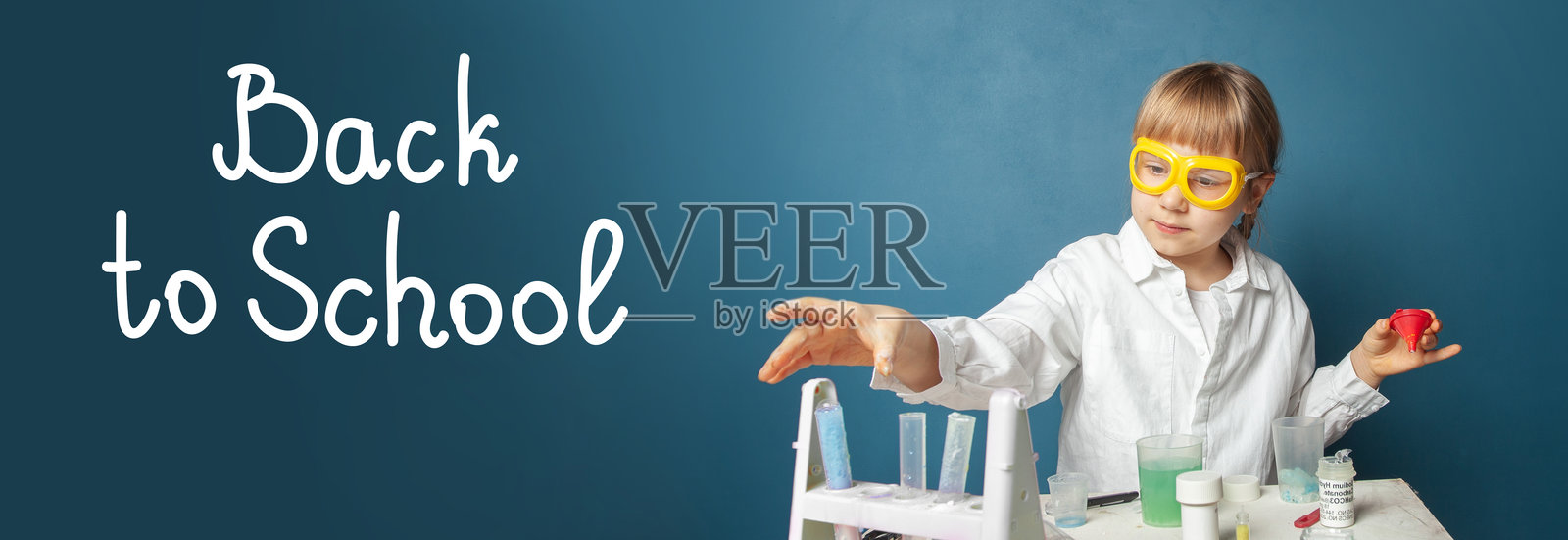 蓝色背景上的小学生。教育和返校概念照片摄影图片