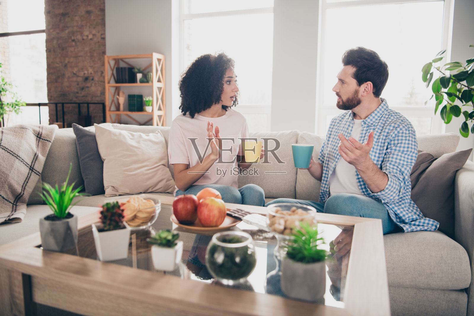 两个漂亮的年轻伙伴争论喝咖啡的空闲时间周末现代公寓室内的照片照片摄影图片