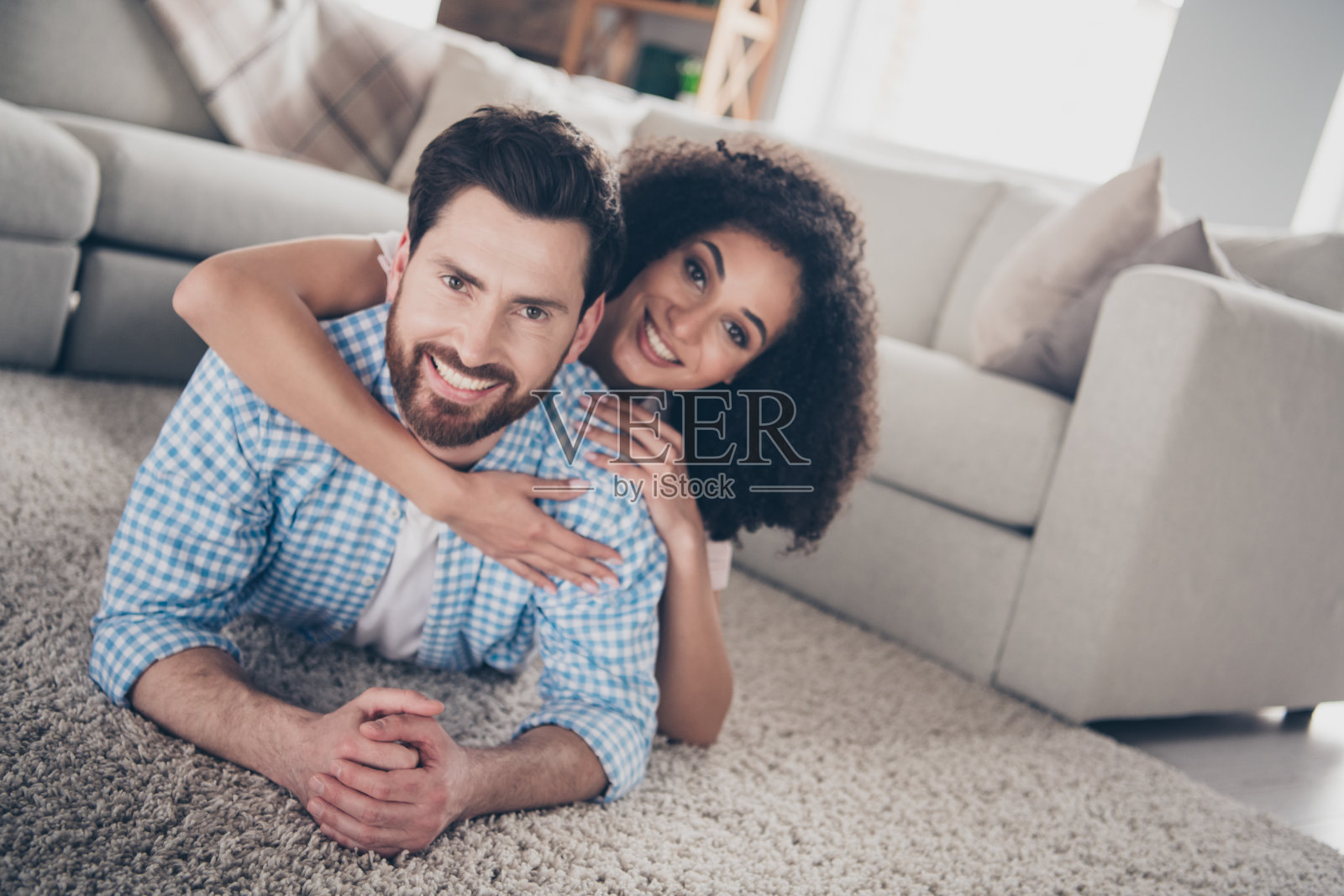 两个年轻的田园诗般的伴侣躺在地板上拥抱现代室内客厅公寓的室内照片摄影图片