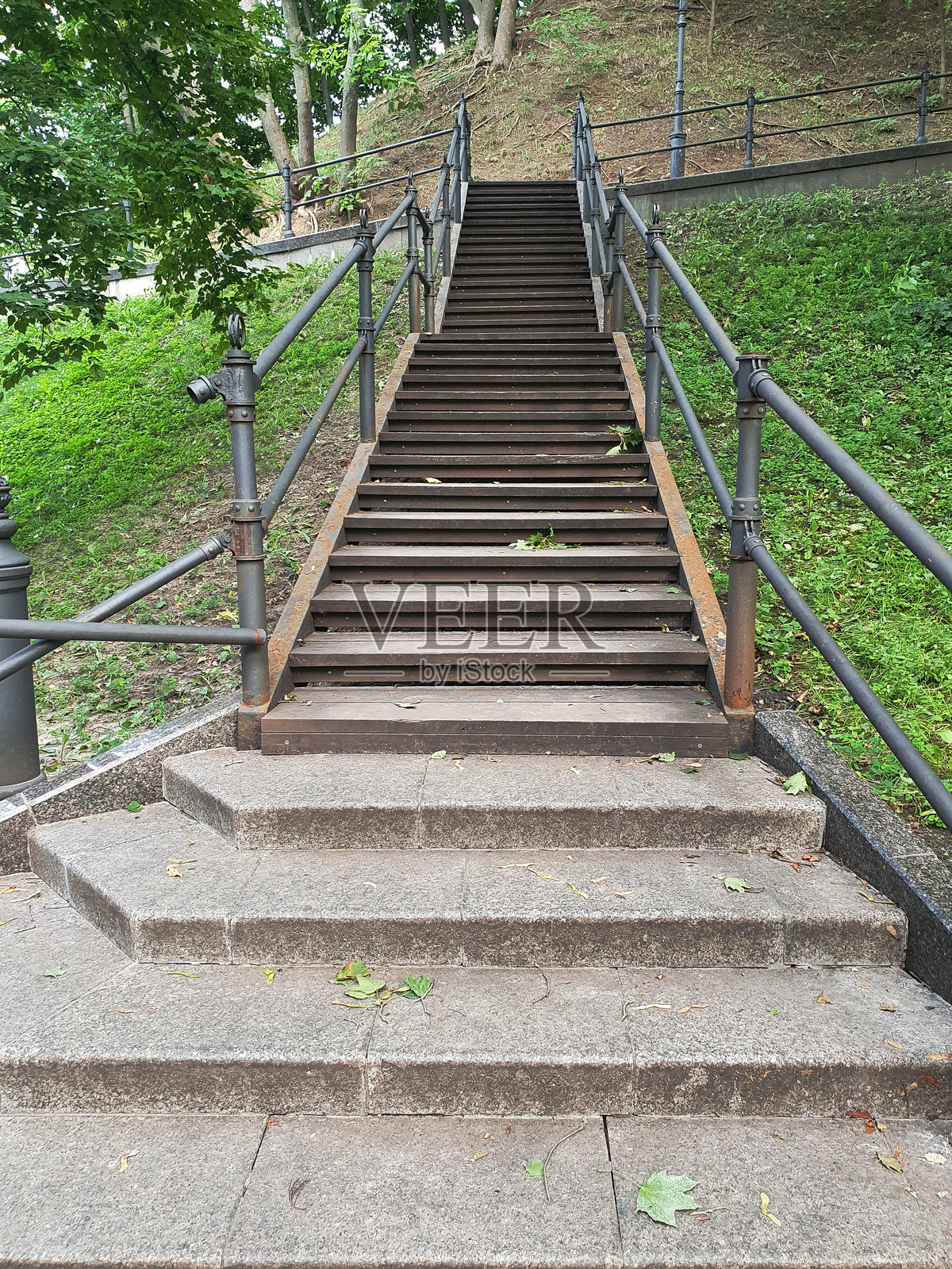 在一个阳光明媚的夏日，公园里有扶手的台阶，人行道照片摄影图片