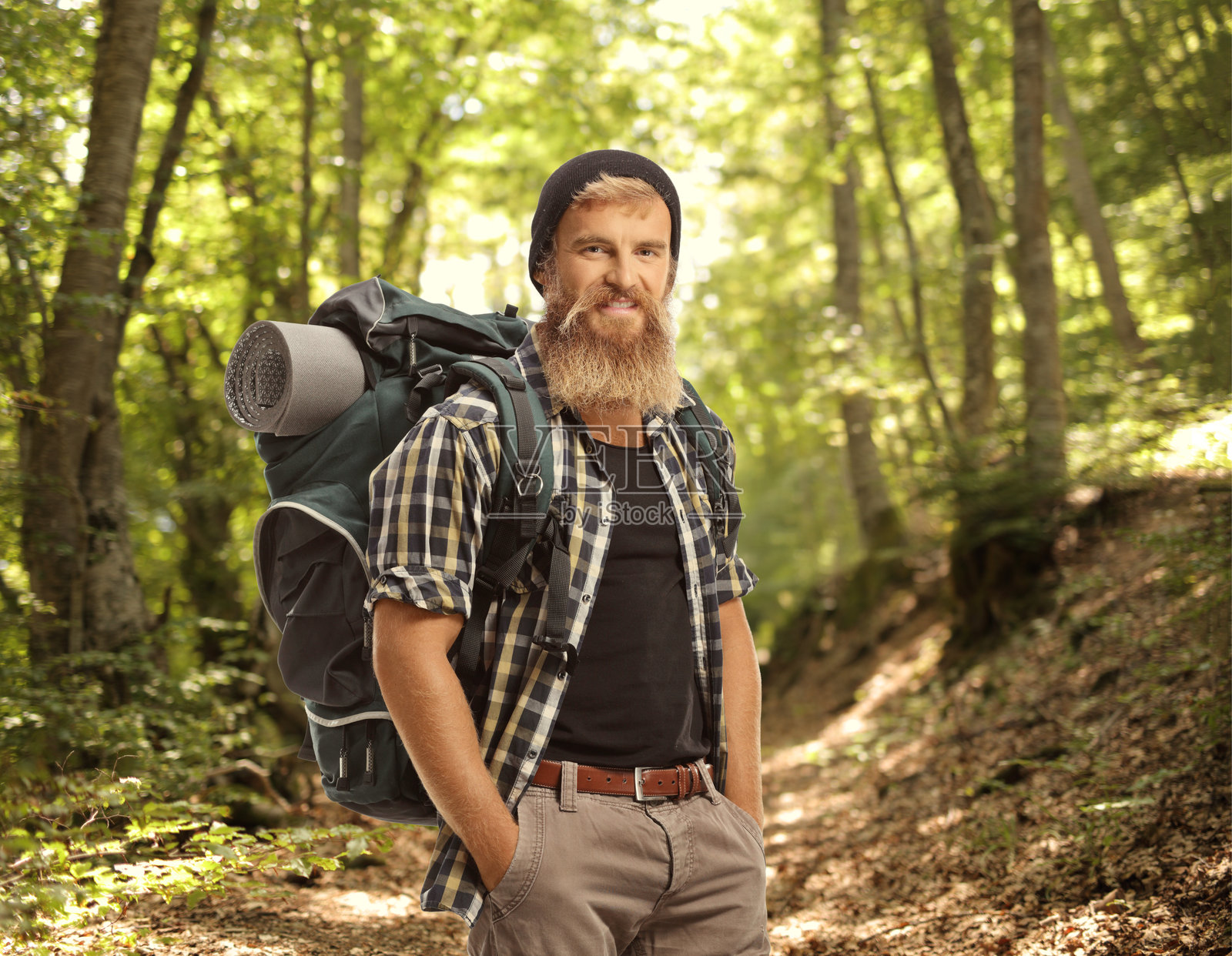 留着胡子的年轻徒步旅行者背着背包在森林里照片摄影图片
