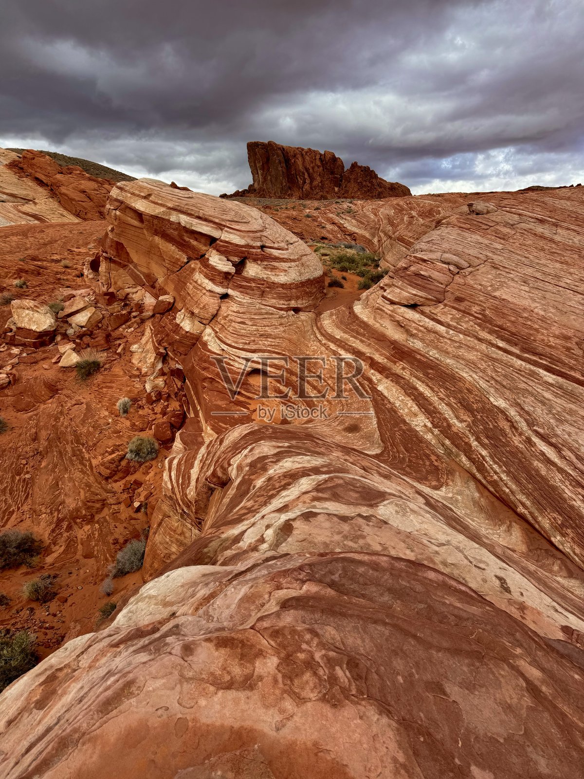 在一个暴风雨的日子里，美国内华达州的火谷州立公园的火波照片摄影图片