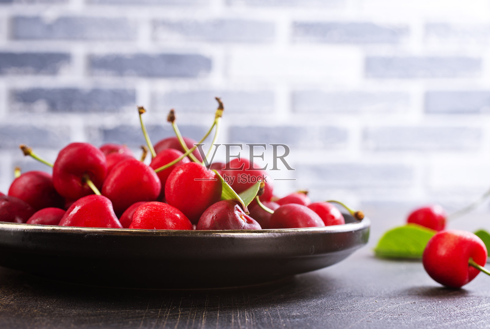 刚收获的樱桃放在碗里。新鲜甜有机樱桃照片摄影图片