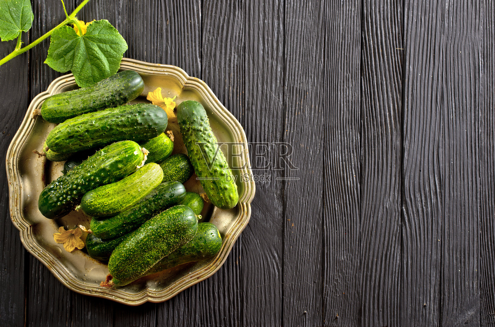 新鲜健康的有机黄瓜装在金属盘子里。照片摄影图片