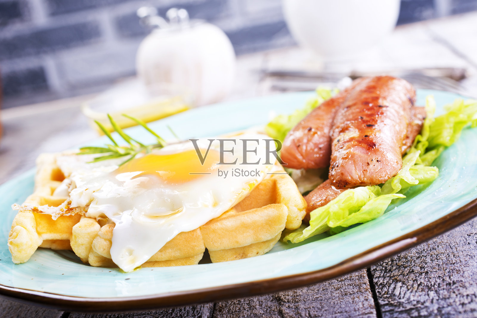 美味的早餐。放在木桌上，配上烤面包、鸡蛋、香肠、薄饼和果汁。照片摄影图片