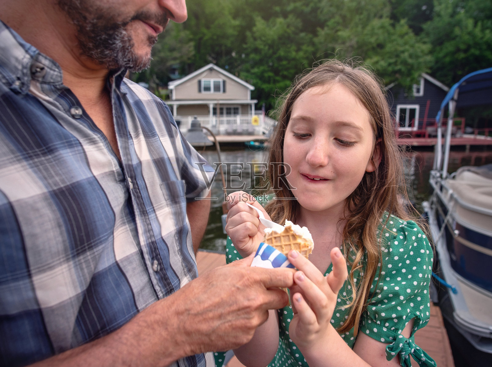 在湖边分享甜蜜时光。父亲和女儿在波科诺斯咖啡馆享用冰淇淋。照片摄影图片