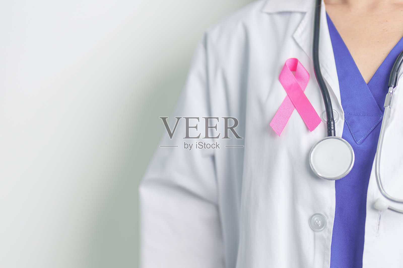 粉红十月乳腺癌宣传月，带着粉红丝带的女医生在医院支持人们的生命和疾病。全国癌症幸存者月，母亲和世界癌症日的概念照片摄影图片