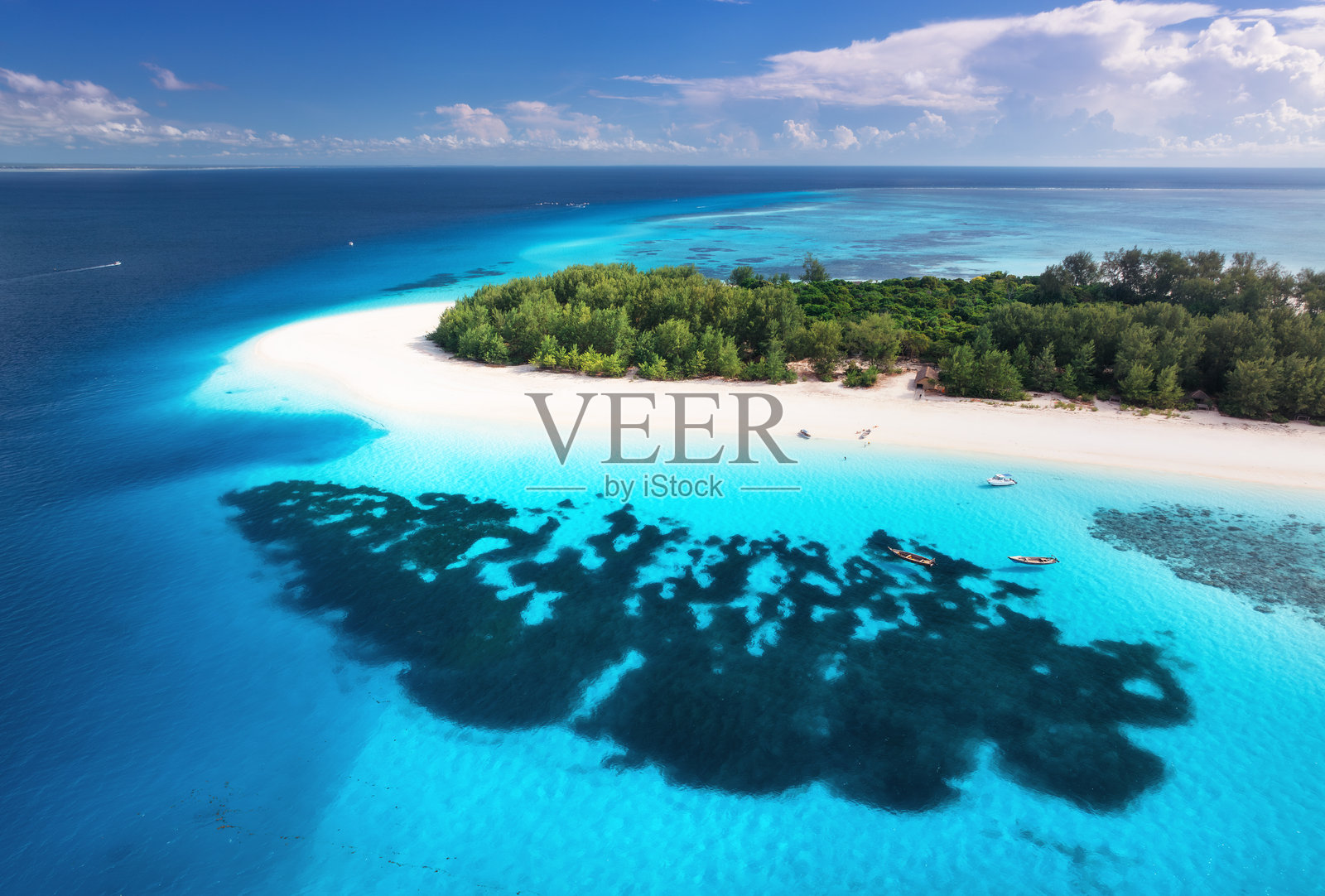 鸟瞰桑给巴尔蔚蓝的大海和令人惊叹的曼内巴岛。俯视图白色沙滩，绿色的树木，棕榈树，海洋与清澈蔚蓝的水在夏天阳光明媚的日子。热带景观。异国情调。旅行照片摄影图片