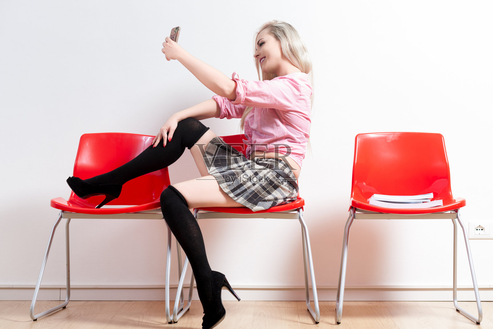 金发女郎坐在红椅子上自拍照片摄影图片