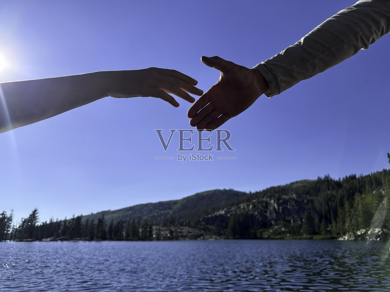 伸出援助之手越过湖面照片摄影图片