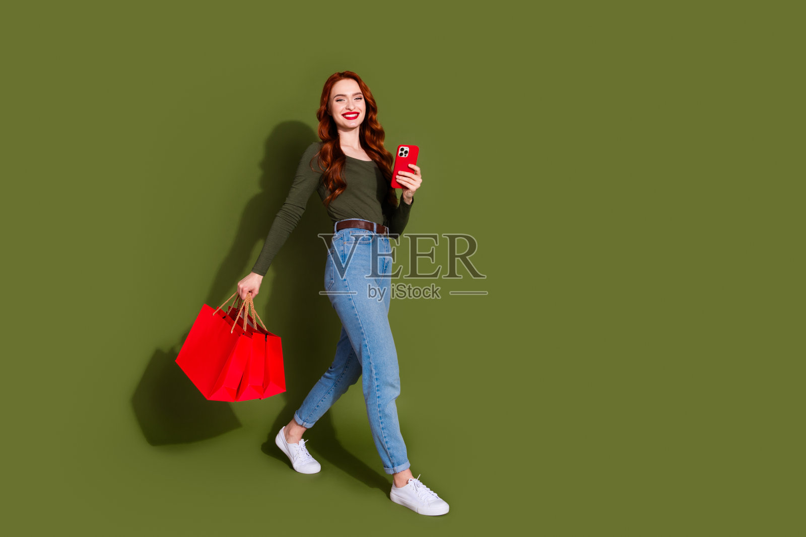 全身照片光泽迷人的女士穿着衬衫拿着便宜货聊天设备空空间孤立的绿色背景照片摄影图片