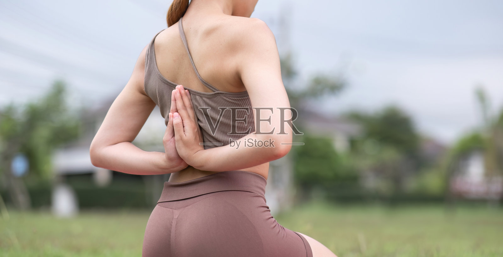 年轻女子在公园练习瑜伽，反向祈祷姿势，户外健身和健康概念照片摄影图片