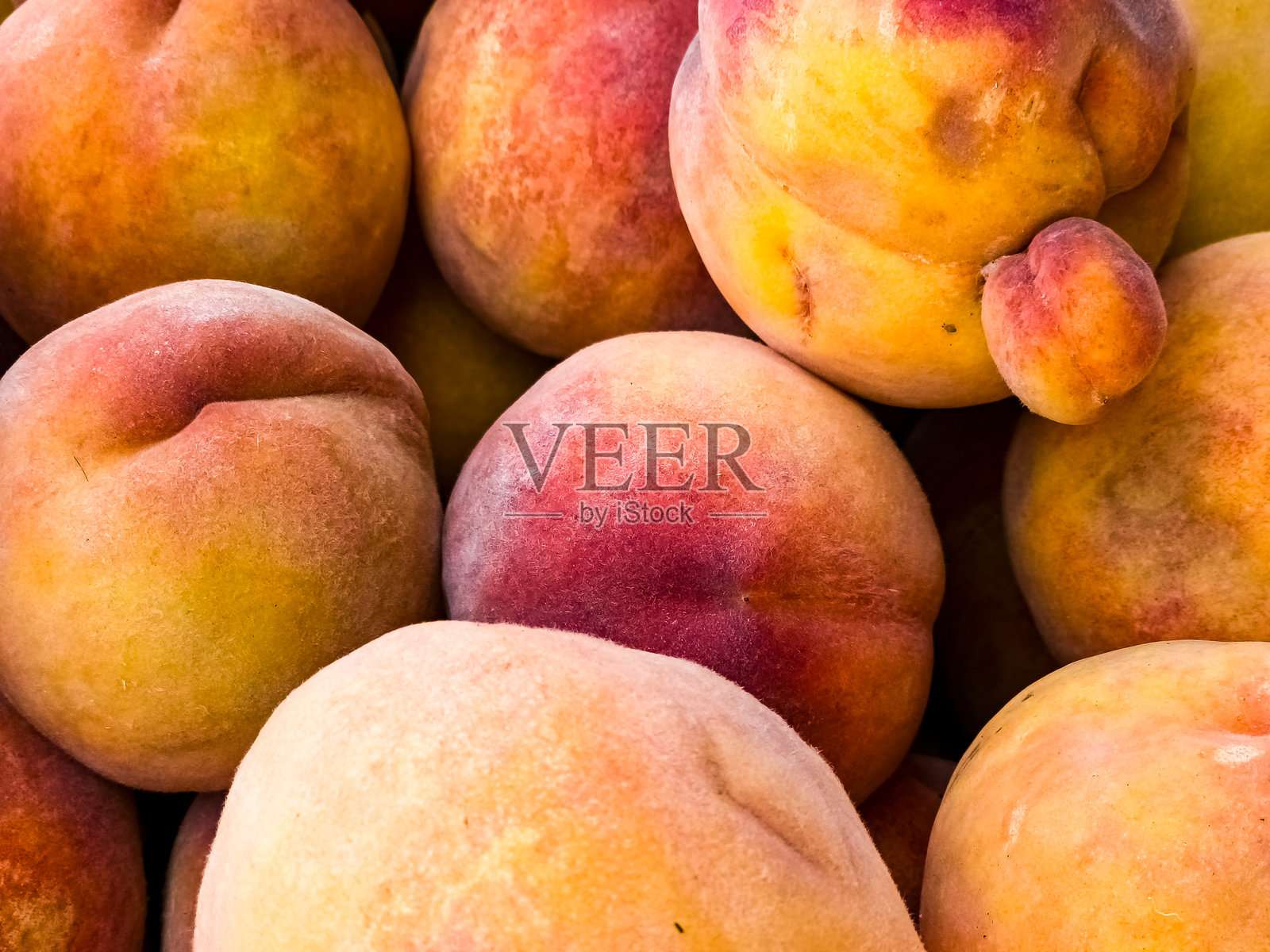 新鲜成熟的桃子作为背景。农贸市场的水果。有机产品照片摄影图片