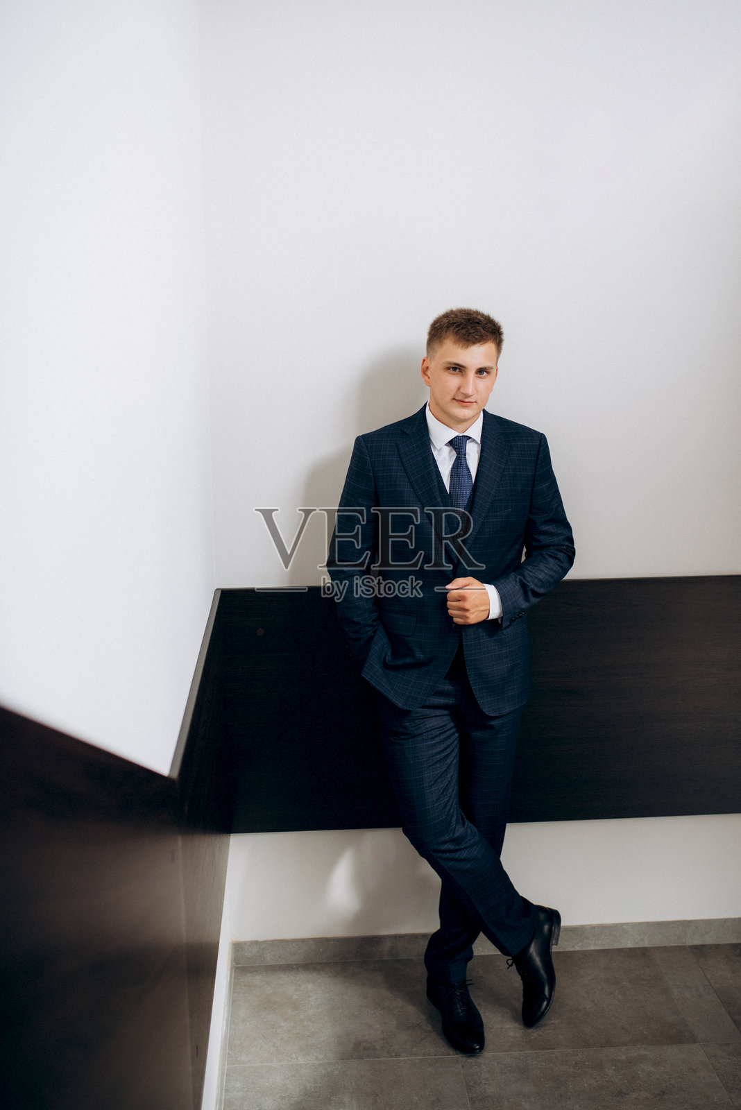 婚礼当天新郎身穿蓝色三件套西装打着领带的照片照片摄影图片