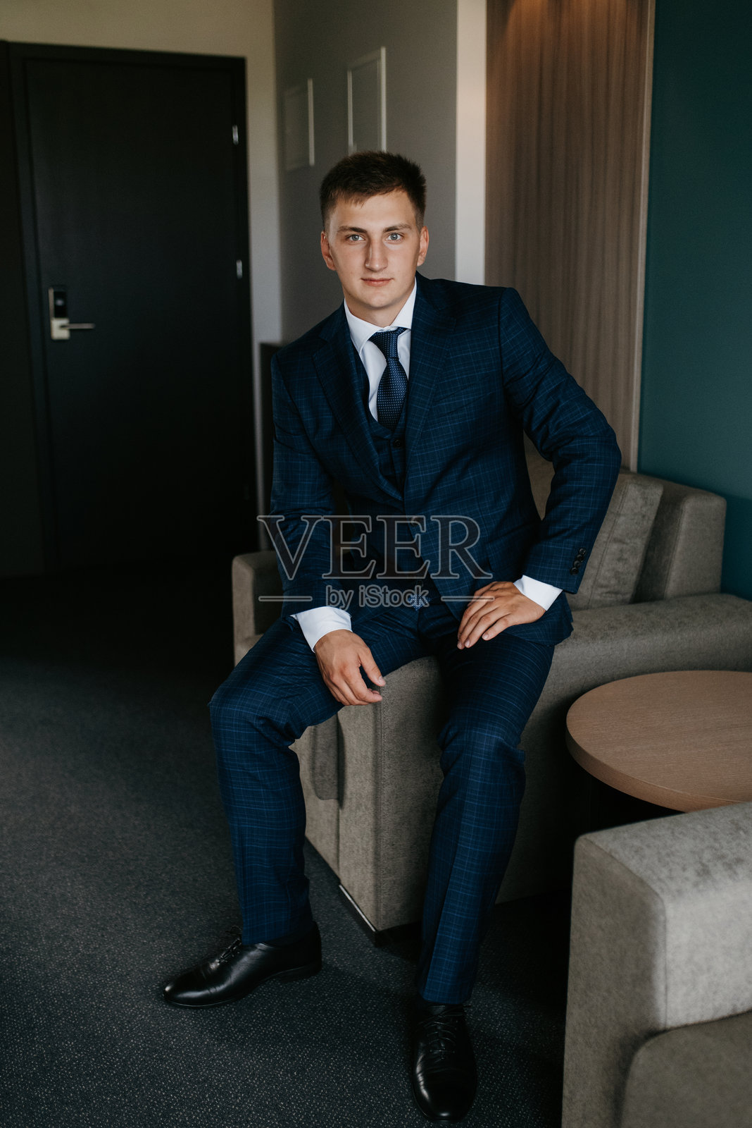 婚礼当天新郎身穿蓝色三件套西装打着领带的照片照片摄影图片