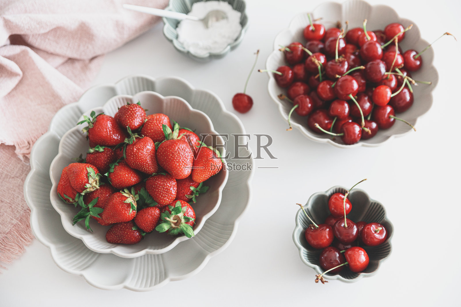 新鲜的夏季浆果装进白色桌子上的碗里。夏季食物概念。俯视图照片摄影图片