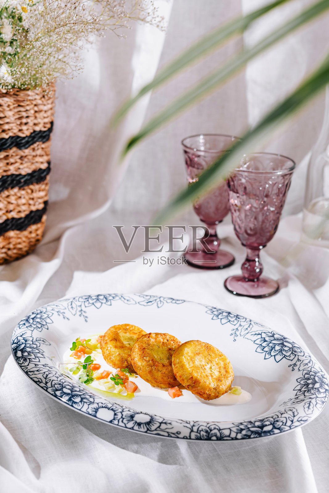 土豆煎饼放在盘子里，配上白酱和绿色蔬菜照片摄影图片