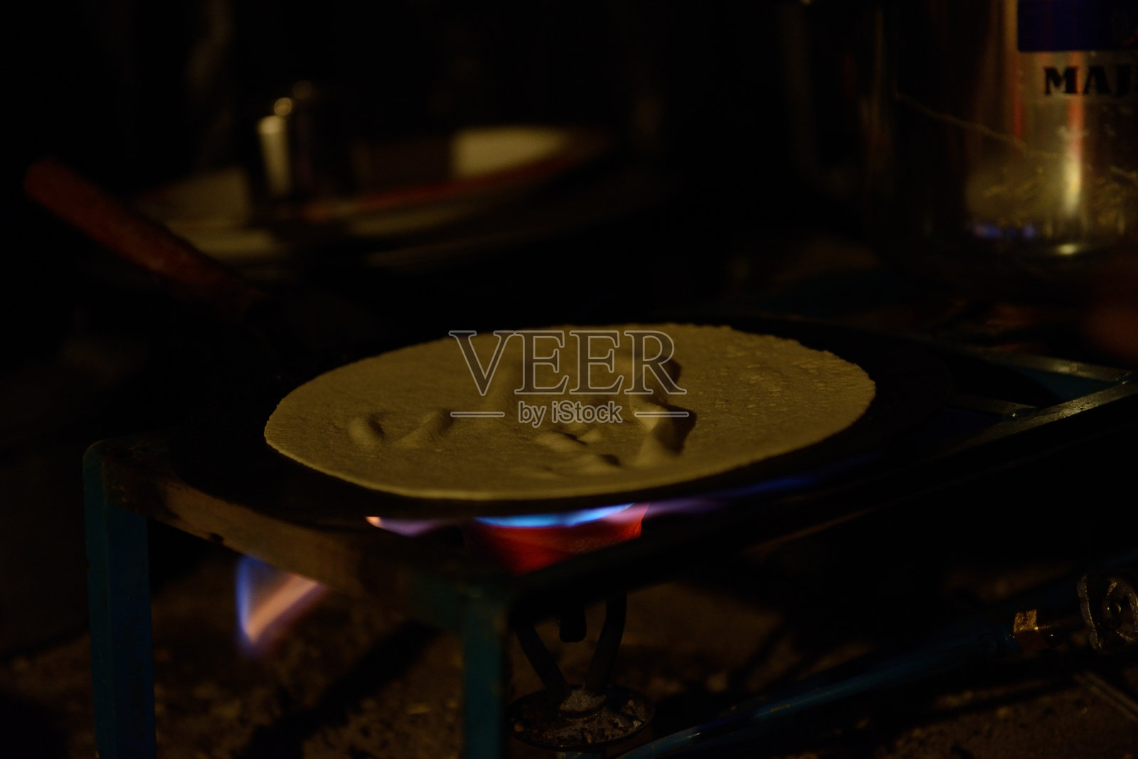 在Biafo冰川露营期间,平底锅上的大饼和下面的炉子照片摄影图片